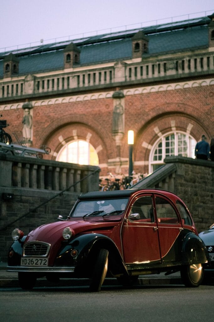 Rode Citroën 2CV oldtimer geparkeerd in de stad, passend bij een oldtimerverzekering voor klassieke auto’s.