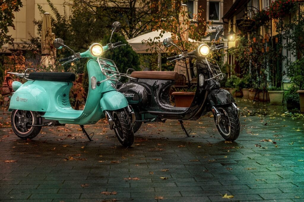 Twee scooters geparkeerd in de stad, passend bij informatie over een scooterverzekering