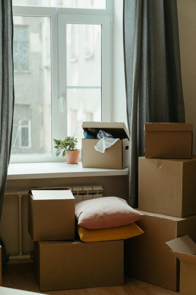 pexels photo 4569338 4569338 Stack of moving boxes in a sunlit room, symbolizing a fresh start in a new apartment.